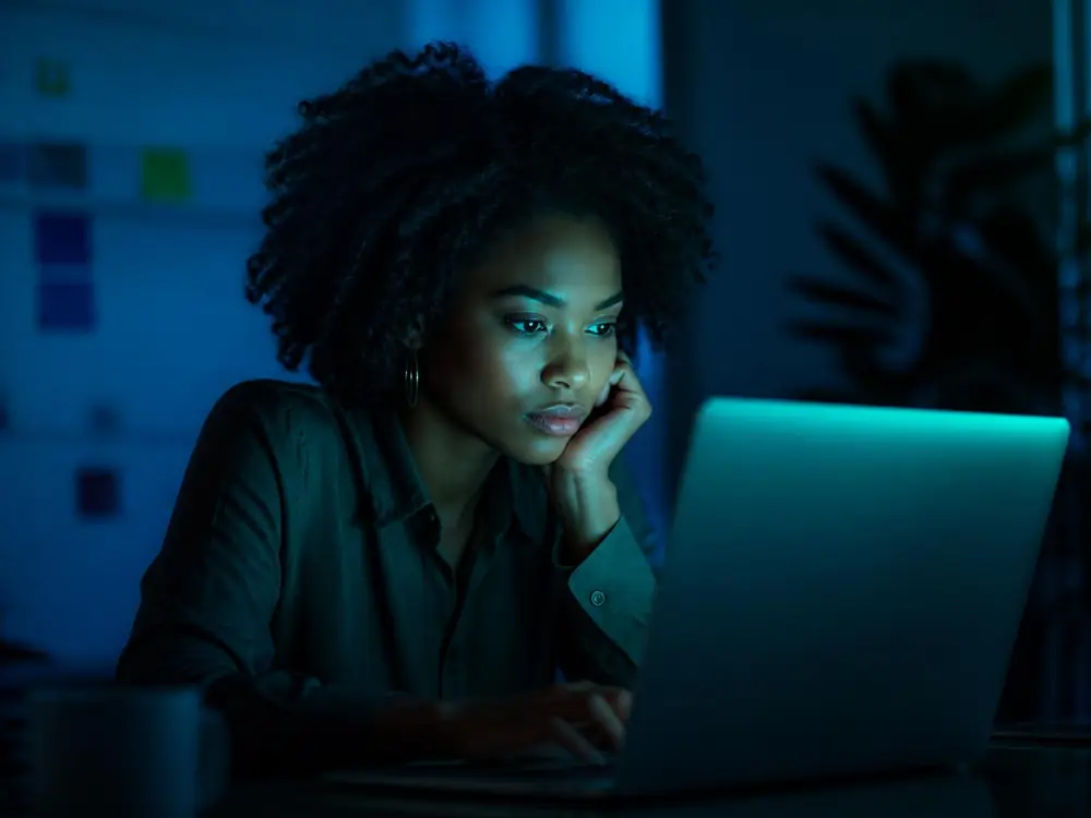 Woman analyzing media on a laptop at night